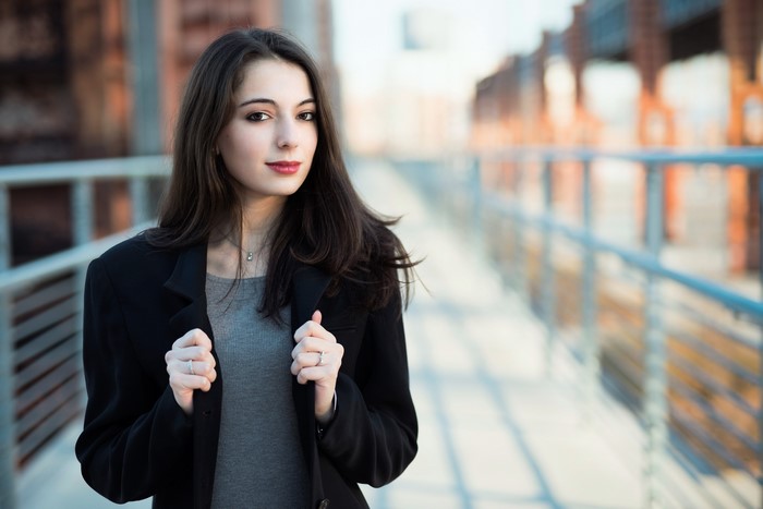 Brunette girl in a black jacket on a bridge