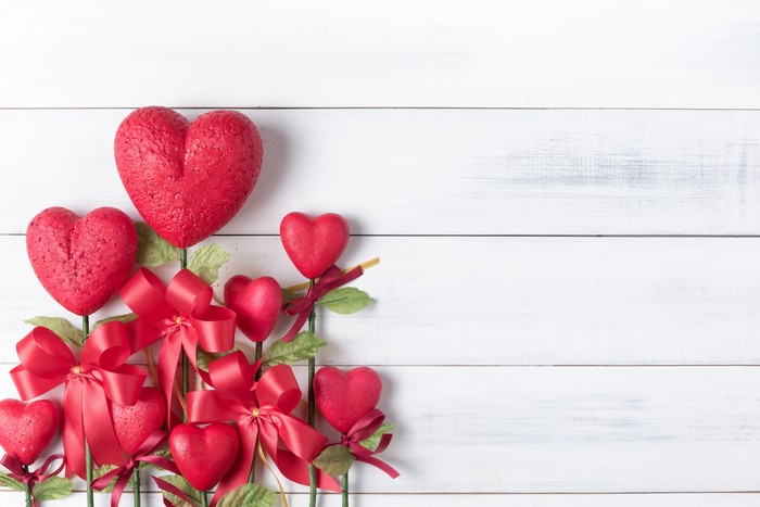 Valentine's Day red hearts with bows on wood planks