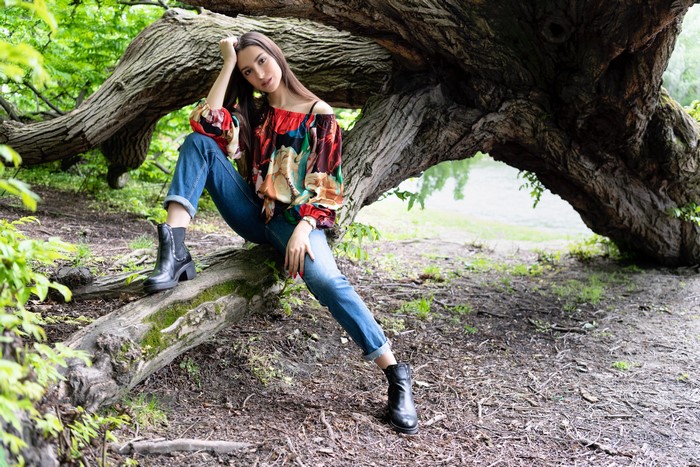 Woman sitting on a tree branch in a forest