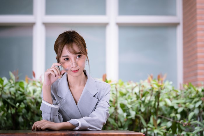 Asian Woman with Glasses Sitting Outdoors