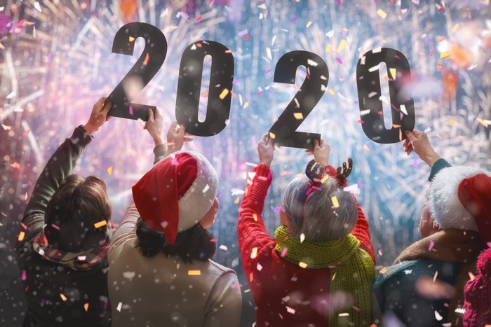 People holding 2020 numbers with fireworks
