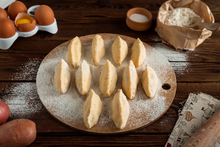 Pierogi Varenyky dough on a cutting board with ingredients