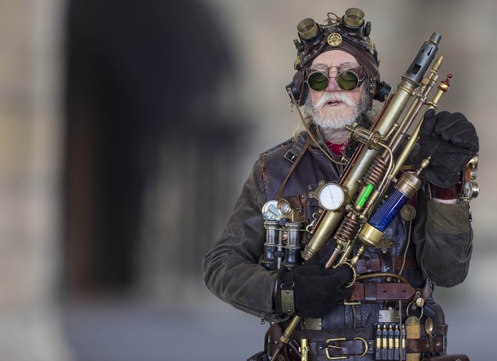 Man in Steampunk Costume Holding a Prop Weapon