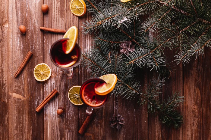 Christmas mulled wine with citrus and cinnamon on wood