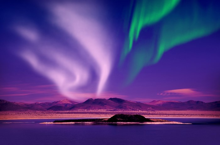 Aurora Borealis over a lake and mountains