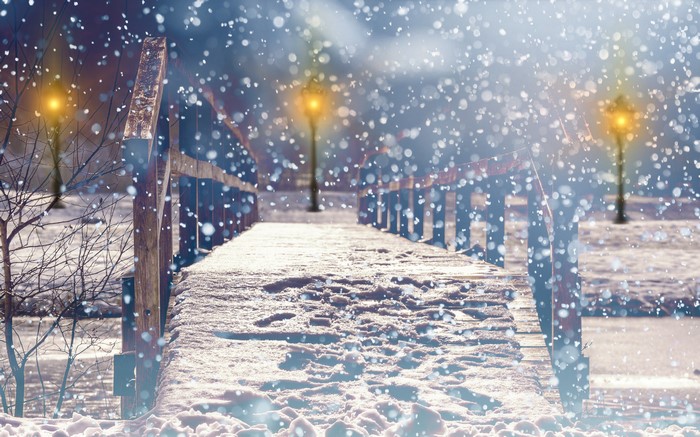 Snowy bridge with street lights at night