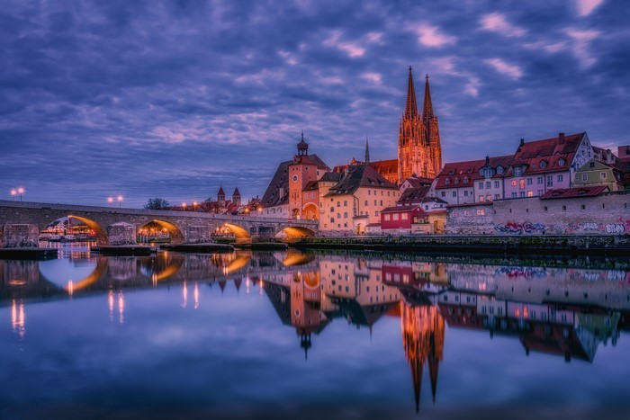 Regensburg skyline with bridge and river at dusk