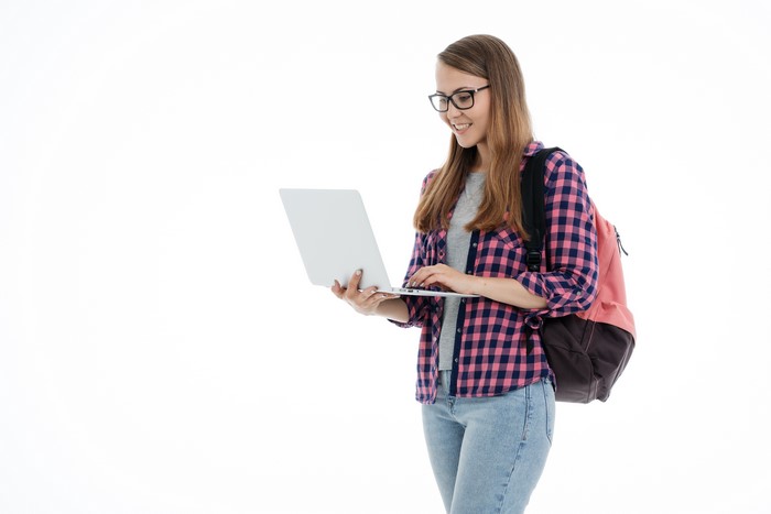 Young woman with glasses and backpack using a laptop