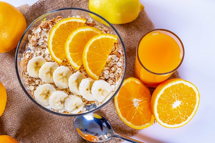 Muesli with orange and banana, orange juice, and lemon