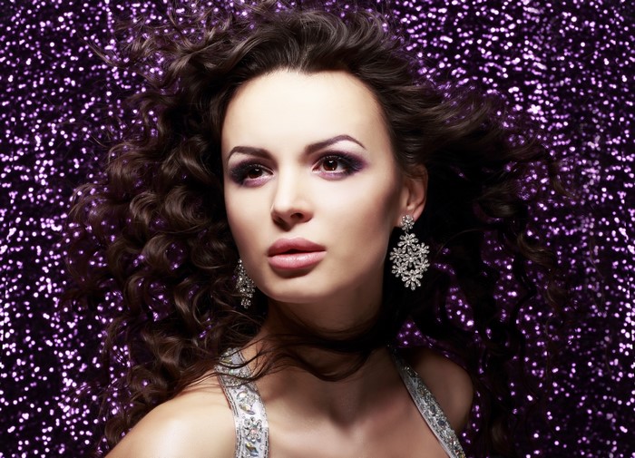 Woman with curly brown hair and earrings
