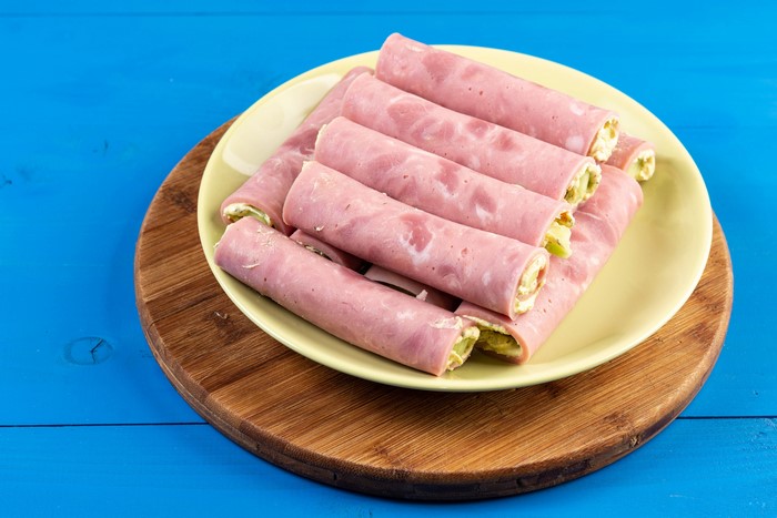 Ham rolls on a plate on a cutting board