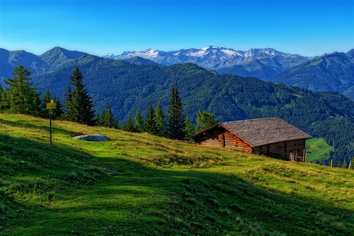 Wooden cabin on a grassy slope in the Alps, Austria
