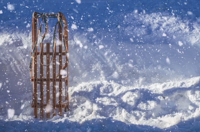 Wooden sled in falling snow