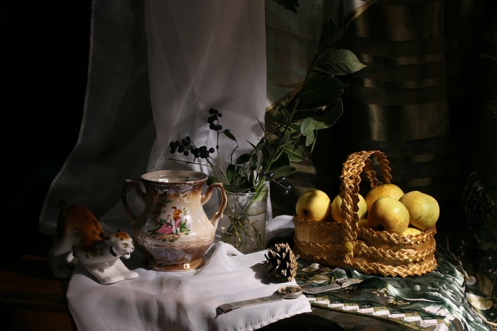 Still-life with apples in a wicker basket and a decorative jug