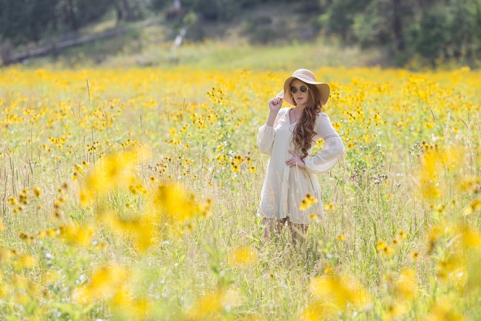 Woman in a Hat and Dress in a Field of Yellow Flowers