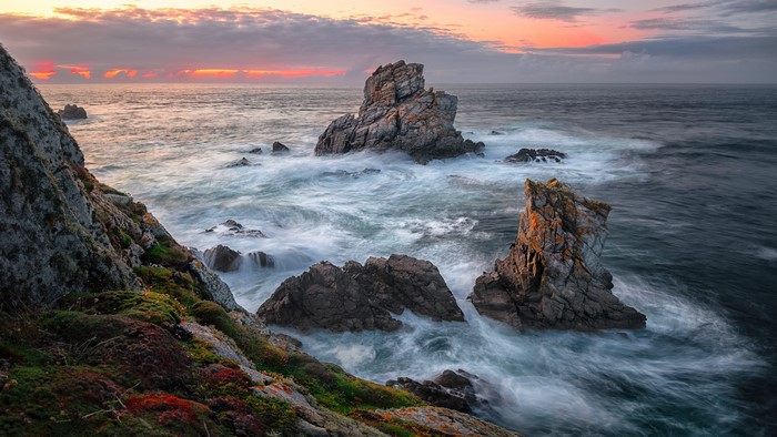 Sea Waves Crashing on Rocky Coastline at Sunset