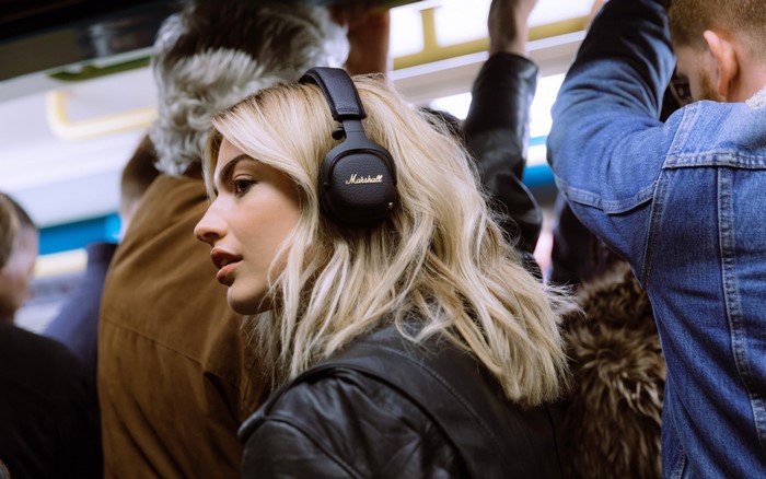 Woman wearing Marshall headphones on a train