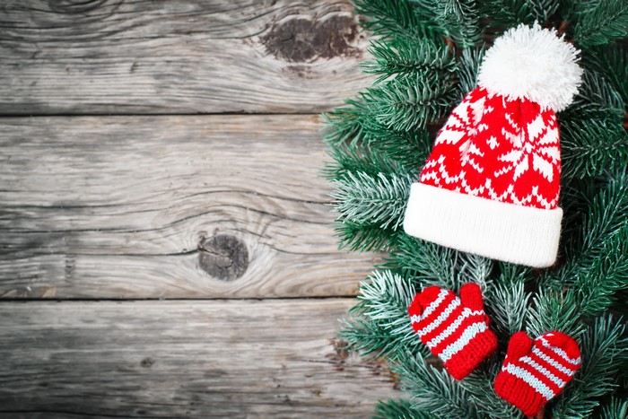 Christmas hat and mittens on wood planks