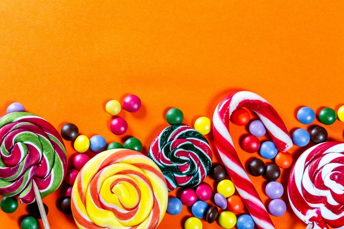 Assortment of Lollipops and Candies on Orange Background