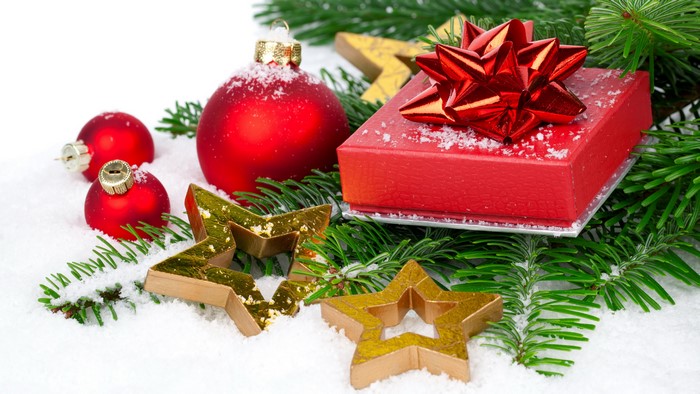 Christmas ornaments, gift, and fir branches in snow