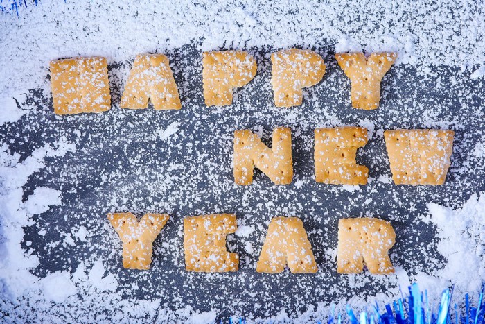 Happy New Year cookies with powdered sugar and tinsel