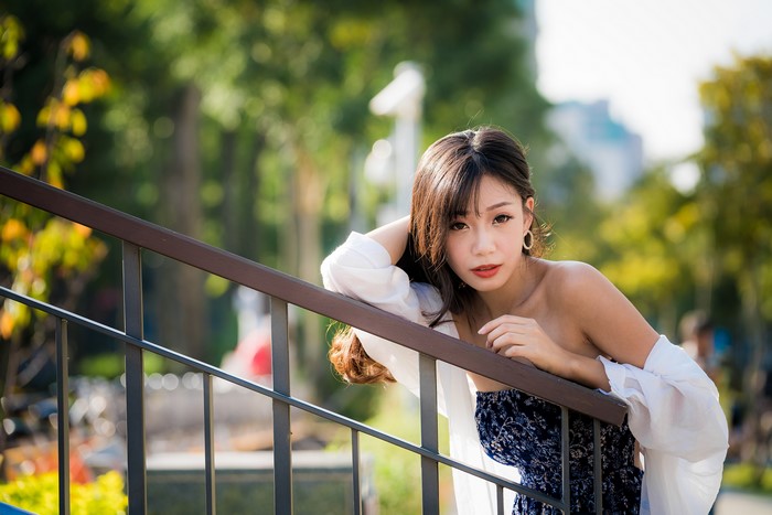 Asian woman posing on stairs with bokeh background