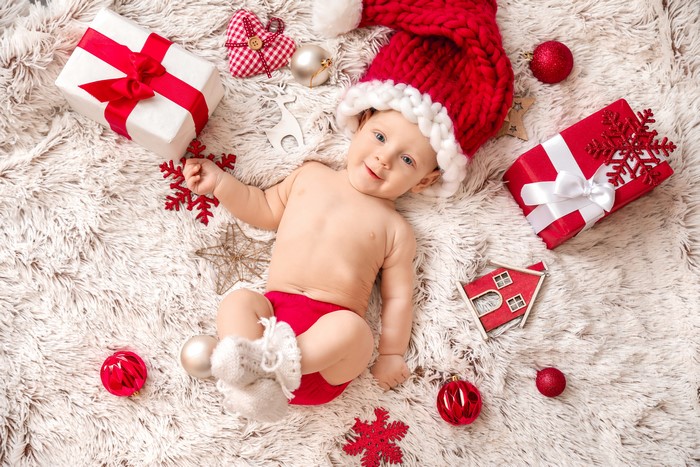 Baby in Santa hat with Christmas gifts