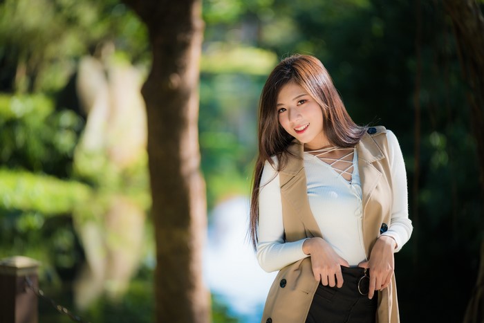 Asian woman with brown hair smiling in a park