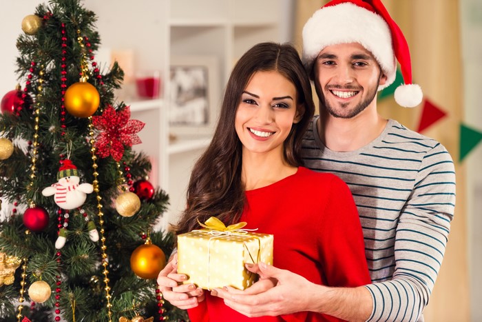 Couple with Christmas Gift by Tree