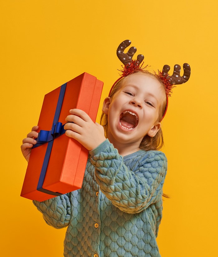 Girl with reindeer antlers holding a gift