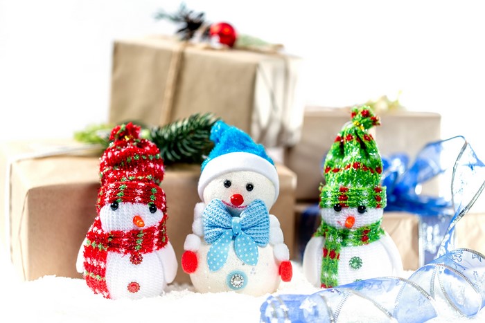 Three snowmen with Christmas gifts and decorations
