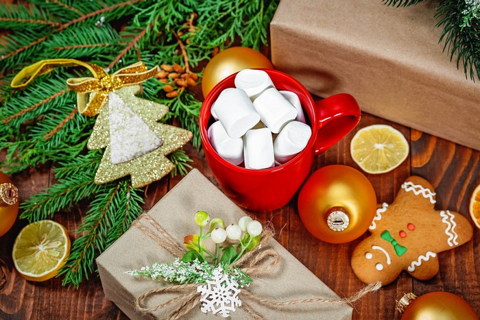 Christmas scene with gifts, hot chocolate, and gingerbread cookie
