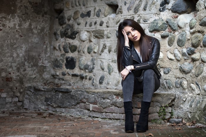 Carlotta sitting on stone steps in front of a stone wall