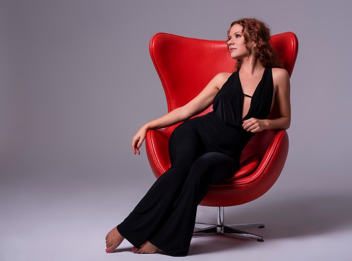 Alba Morales sitting in a red armchair