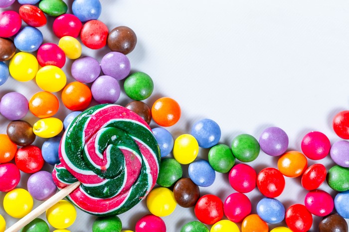 Multicolor candies and a lollipop on a white background