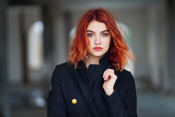 Redhead girl with red lips and black coat