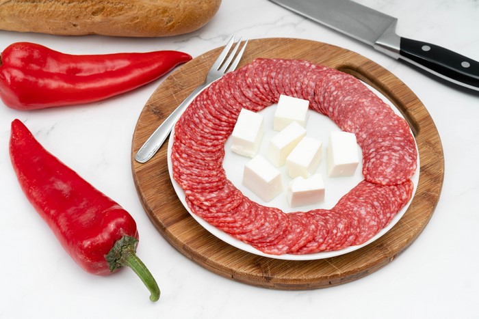 Sausage, Cheese, and Chili Peppers on Cutting Board