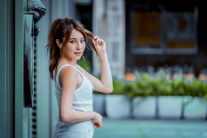 Asian woman with brown hair in a white top