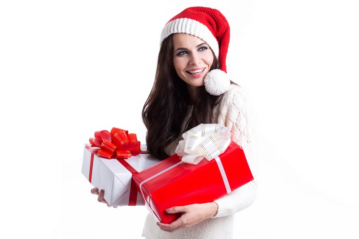 Brunette girl in Santa hat with Christmas gifts