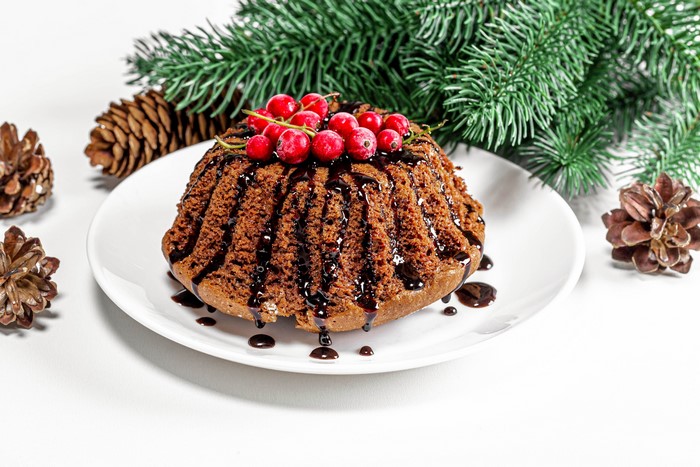 Chocolate bundt cake with red berries and pine cones
