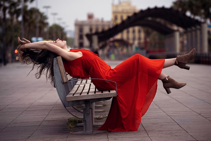 Woman in red dress posing on a bench