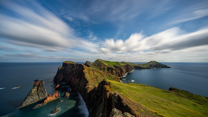 Coastal cliffs and ocean with streaking clouds