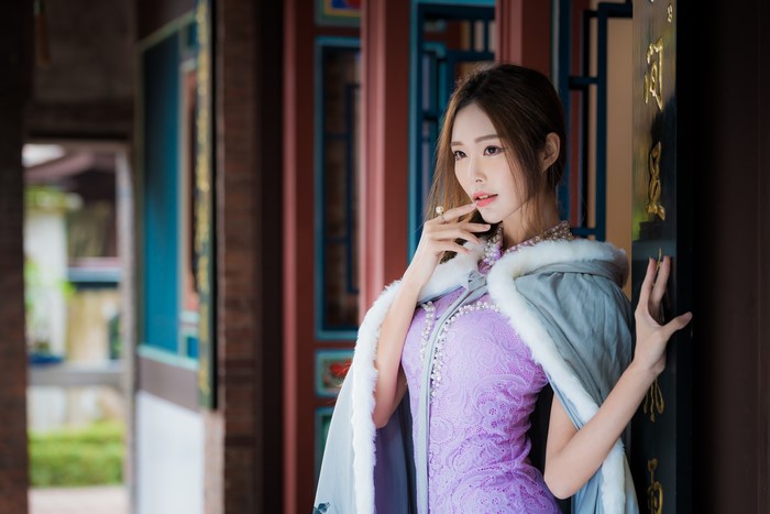 Asian woman in purple dress with fur-lined cape
