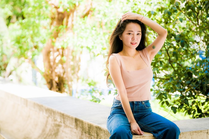 4K Asian Woman Sitting on Concrete Wall