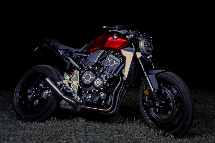 Red Honda CB1000R motorcycle parked on grass at night