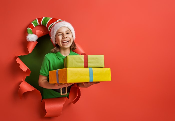 Girl in Elf Hat Holding Christmas Gifts