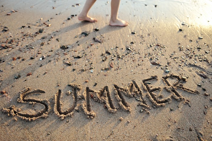 Summer written in sand on a beach