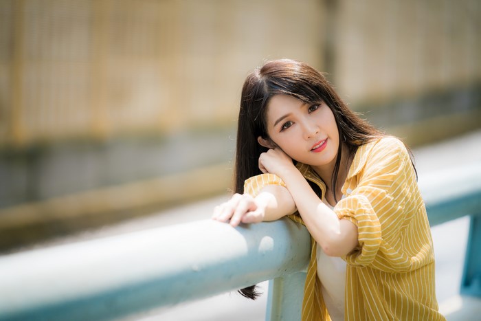 Asian woman with brown hair in yellow shirt