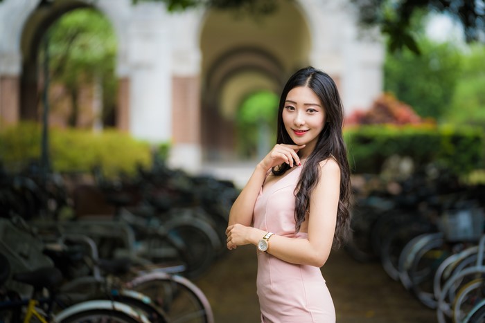 Asian woman in pink dress posing outdoors