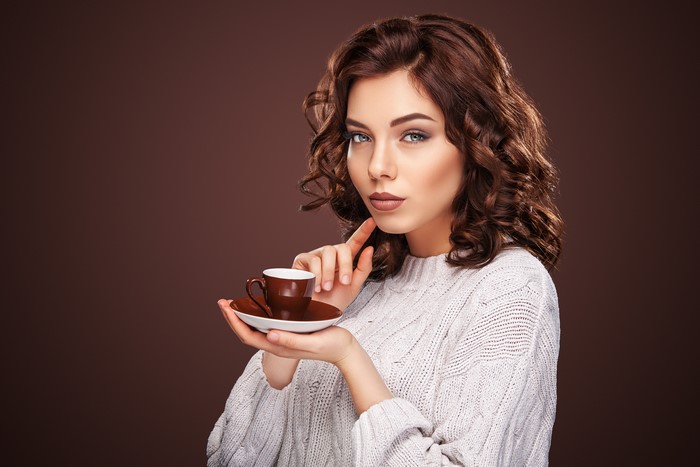 Woman in Sweater Holding Coffee Cup